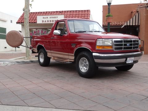 1994 Ford Bronco - This 1994 Ford Bronco is parked on a brick sidewalk in front of a barber shop.