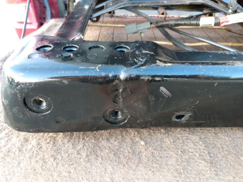 1994 Ford Bronco - Close-up of a vehicle seat frame bracket, showing mounting points and electrical connectors.