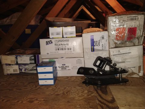 1996 Ford Bronco - Various automotive parts, including a ring and pinion kit and taillights, are stored in an attic space.