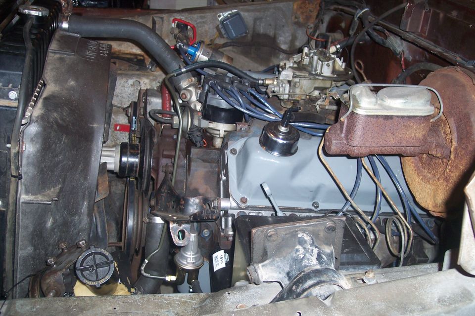 Engine bay showing V8 engine, carburetor, radiator, and brake master cylinder