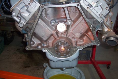 1978 Ford Bronco - Close-up view of an engine block and its components, with oil being drained.