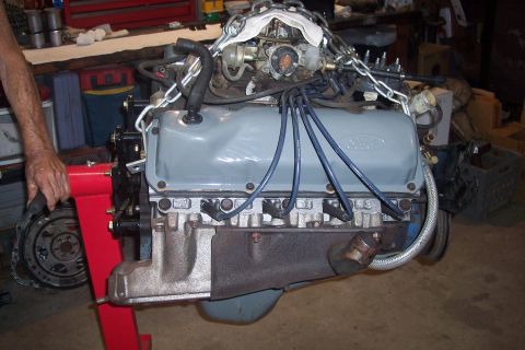 1978 Ford Bronco - Engine assembly, likely a Ford V8, is mounted on a red engine stand for service or rebuild.