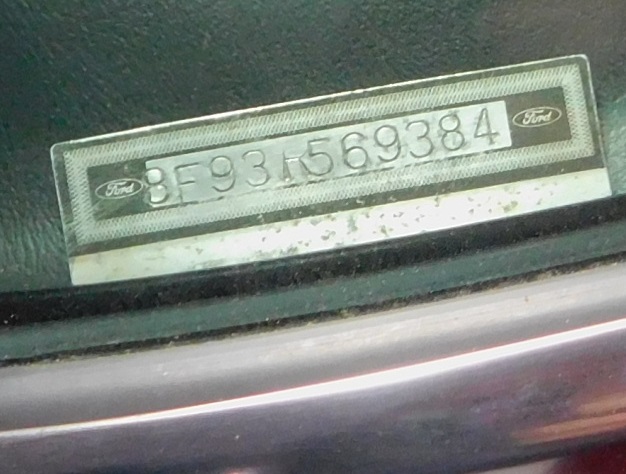 Stamped Ford dashboard VIN plate beginning 8F93 and ending 569384, flanked by Ford ovals