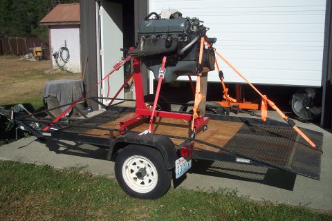 1978 Ford Bronco - An engine is strapped to a stand and loaded onto a utility trailer.
