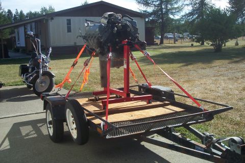 1978 Ford Bronco - Engine and motorcycle being transported on a trailer.