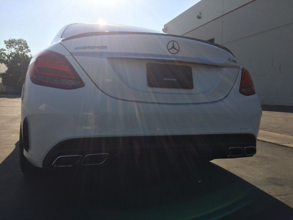 White 2017 Mercedes-Benz C-Class sedan rear view, showing quad exhaust tips and AMG badging