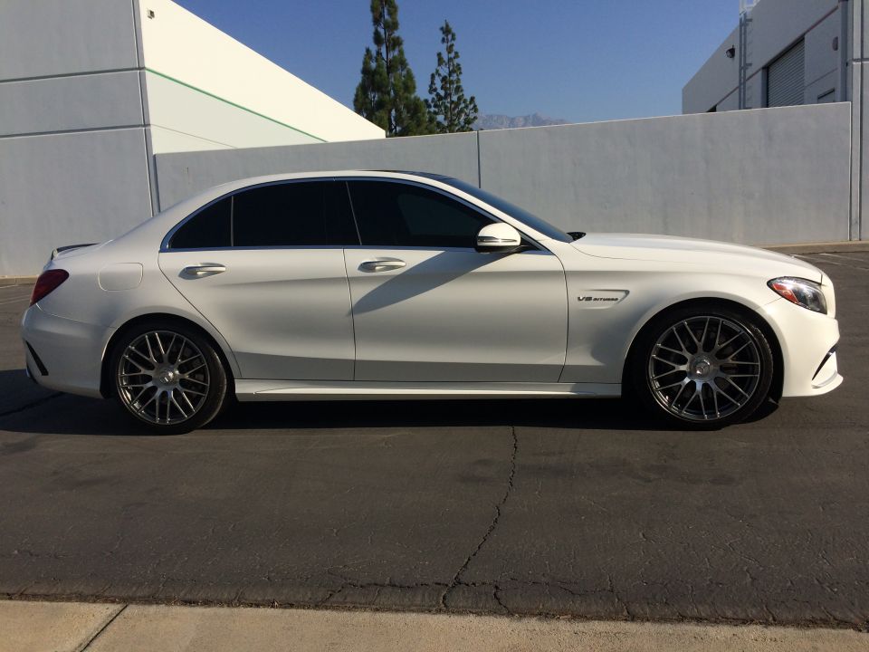 White 2017 Mercedes-Benz C63 S AMG sedan parked outside a building. It has tinted windows and multi-spoke wheels