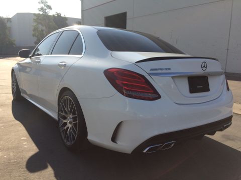 2017 Mercedes-Benz C-Class - Rear view of a white Mercedes-Benz sedan with a spoiler and quad exhaust pipes.