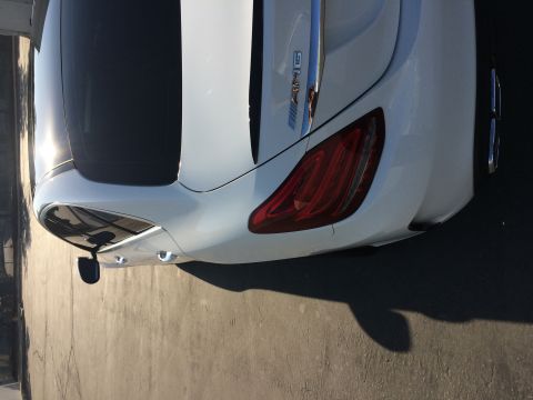 2017 Mercedes-Benz C-Class - Rear view of a white Mercedes-Benz sedan, identified by its AMG badge and distinctive taillights.