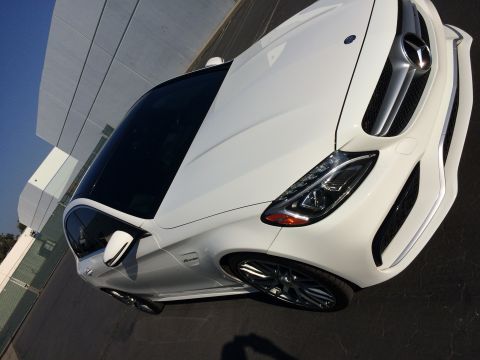 2017 Mercedes-Benz C-Class - A white Mercedes-Benz sedan is captured from a high angle, its design and modern architecture in the background.