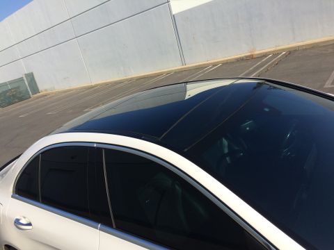 2017 Mercedes-Benz C-Class - A white sedan is shown from a high angle, focusing on its panoramic sunroof and tinted windows.