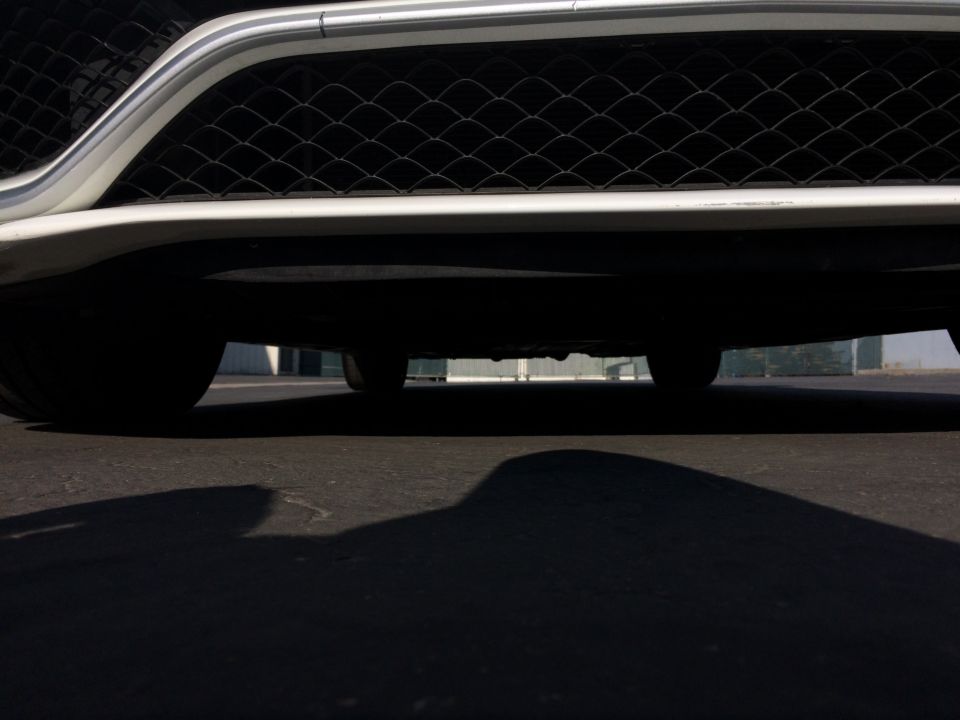 Low angle shot of a car's front grille and the underside of the vehicle