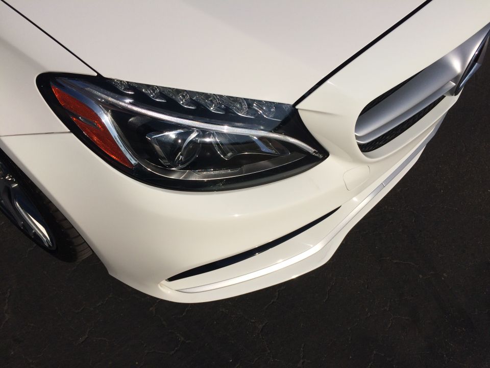 White Mercedes-Benz front corner with headlight and grille detail. 2017 model