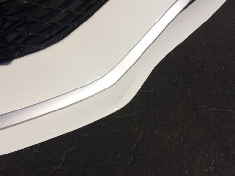 2017 Mercedes-Benz C-Class - Cracked chrome trim on a white car bumper, likely a front or rear section.
