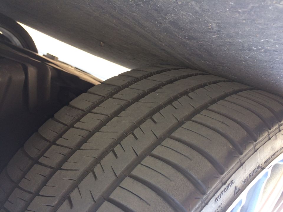 Close-up of a car tire with visible tread. Text 'SUPER MOTORS' and website visible on the rim