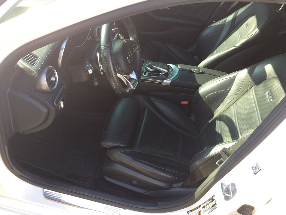 Interior shot of a Mercedes-Benz with black leather seats, steering wheel, and center console