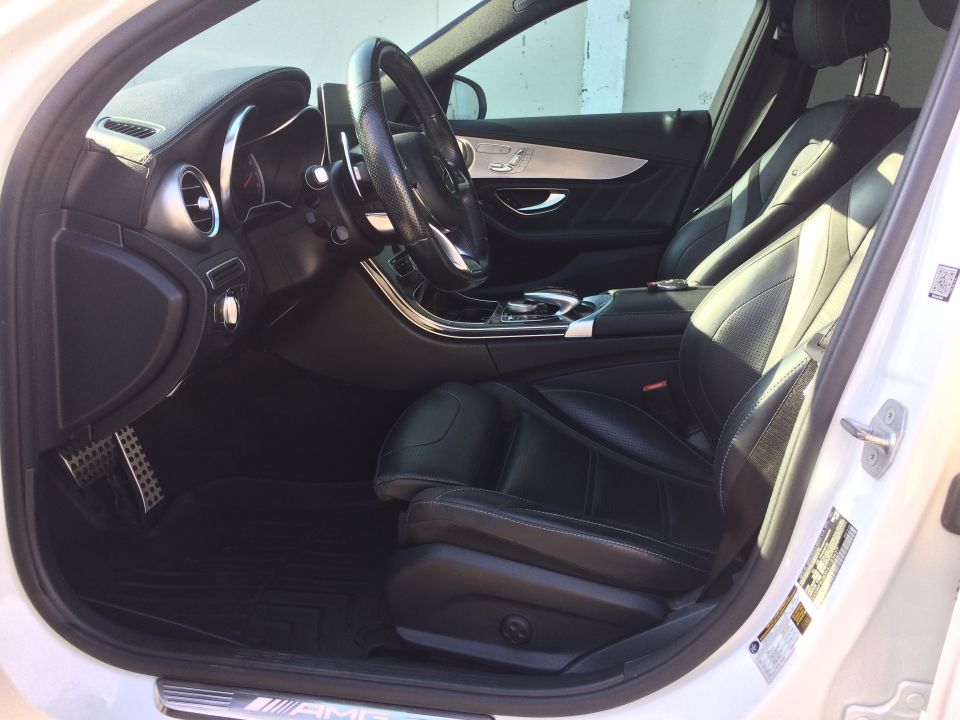 Interior view of a 2017 Mercedes-Benz C-Class showing black leather seats, dashboard, and steering wheel