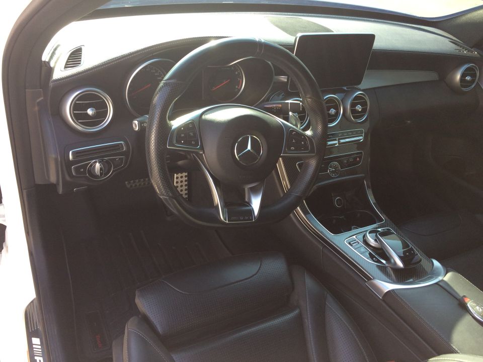 Interior shot of a 2017 Mercedes-Benz C-Class, showing the steering wheel, dashboard, and center console