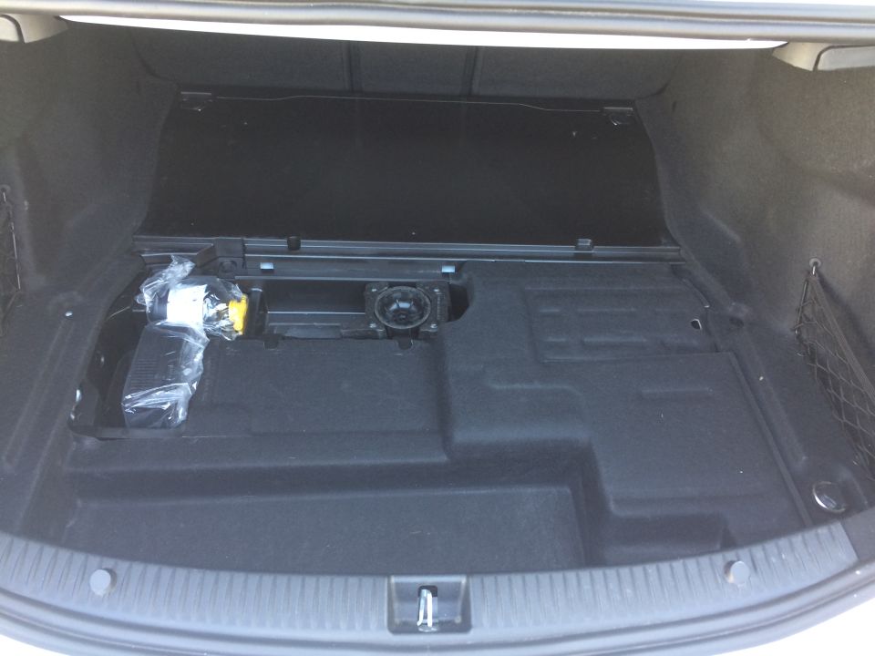 Car trunk with spare tire kit and a speaker