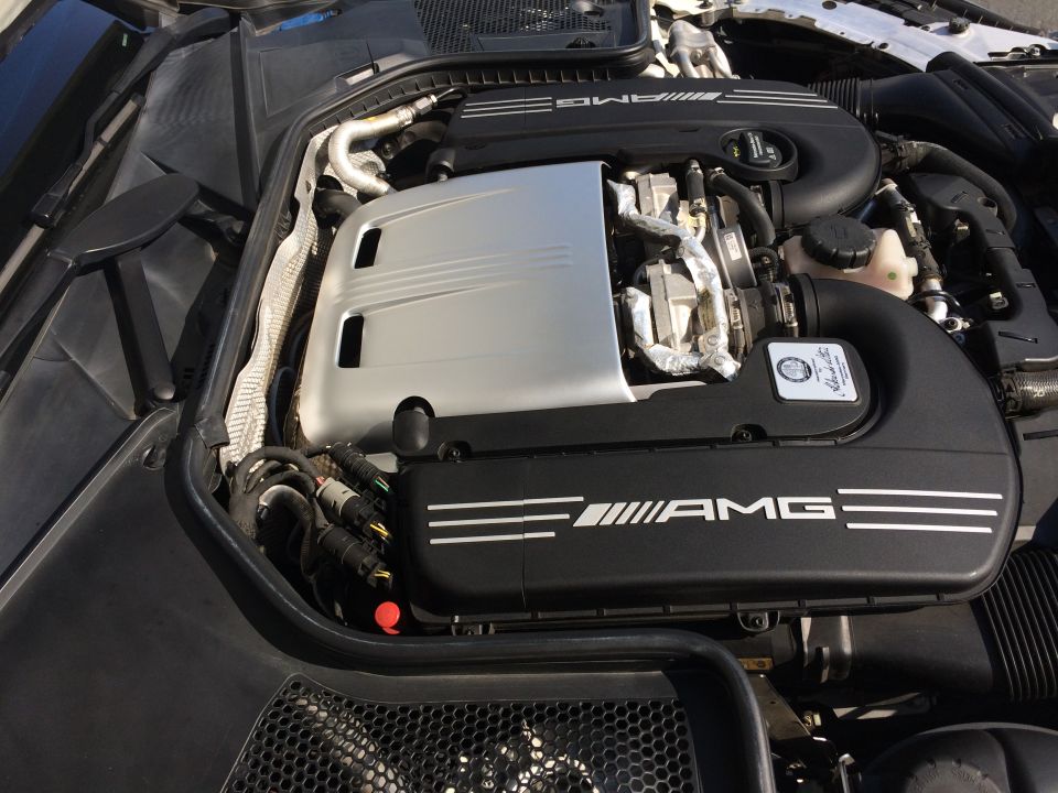 Engine bay of a 2017 Mercedes-Benz C-Class, showing the AMG engine cover and intake system