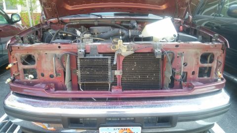 1996 Ford Bronco - Front view of a red truck's engine bay, with the hood open, revealing the radiator and engine components.