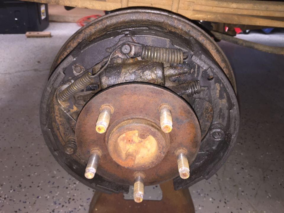 Drum brake assembly with five lug nuts and rusty components
