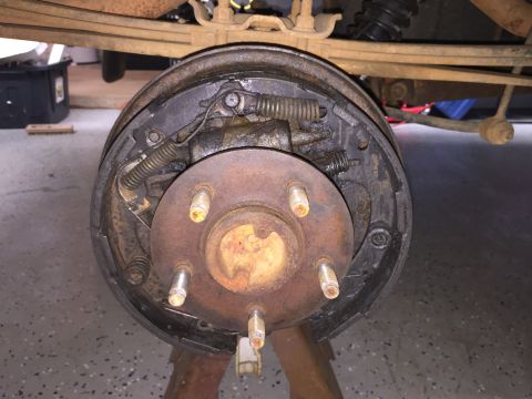 1998 Ford Ranger - Close-up view of a vehicle's rear drum brake assembly, supported by jack stands.