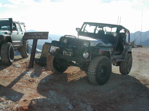 1992 Jeep Wrangler - Two modified Jeeps are parked at a scenic overlook with a sign indicating Imogene Pass and its elevation.