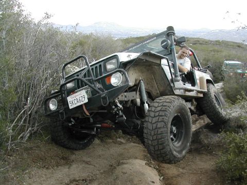 1992 Jeep Wrangler - A 1992 Jeep Wrangler navigates a challenging off-road course with another vehicle visible in the background.