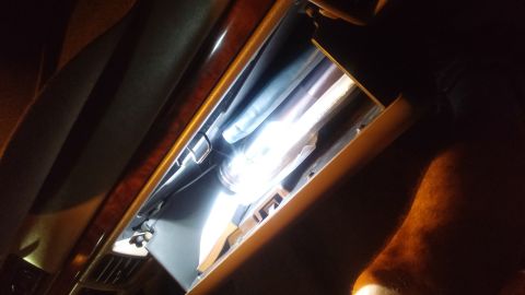 1996 Ford Bronco - The interior of a car's glove box is illuminated by a bright light.