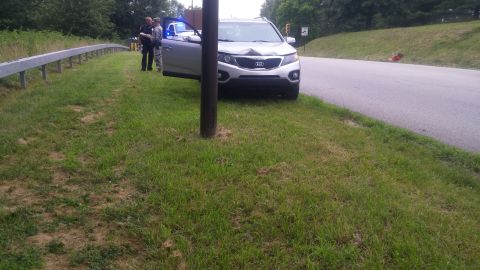 1996 Ford Bronco - A silver SUV is pulled over on the side of the road with its door open, attended by two uniformed individuals.