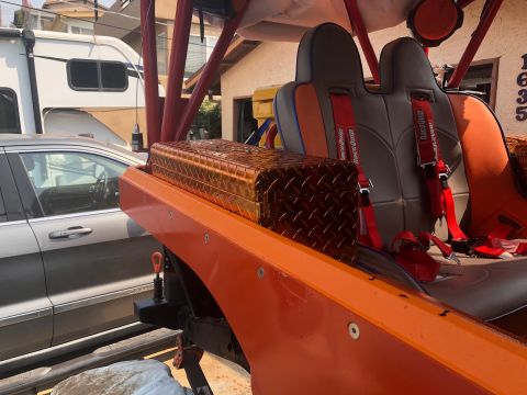 1992 Jeep Wrangler - Interior view of an orange Jeep racing seats and a diamond plate toolbox, with other vehicles in the background.
