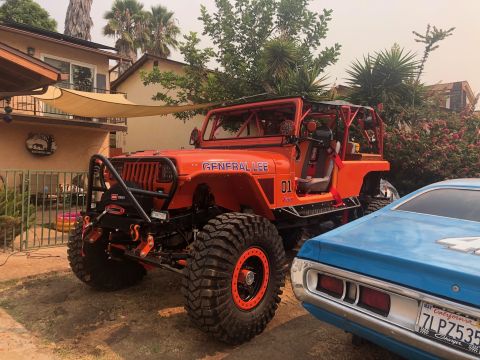 1992 Jeep Wrangler - Modified 1992 Jeep Wrangler, nicknamed 'General Lee', parked next to a blue car.