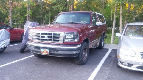 1996 Ford Bronco - This Ford Bronco is parked in a lot with other vehicles nearby. The license plate is visible.