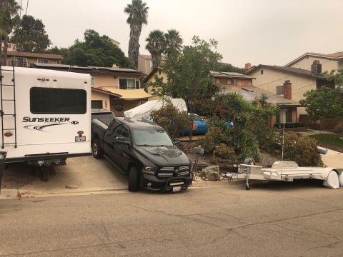 1992 Jeep Wrangler - A black Ram pickup truck is parked in a driveway next to a recreational vehicle.