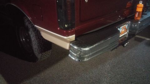1996 Ford Bronco - Close-up of the rear of a maroon Ford F-Series truck, showing the bumper and taillight assembly.