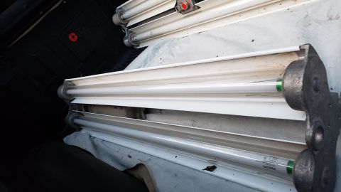 1965 Ford Mustang - Fluorescent light fixtures are stored in a dark area, covered with white cloth.