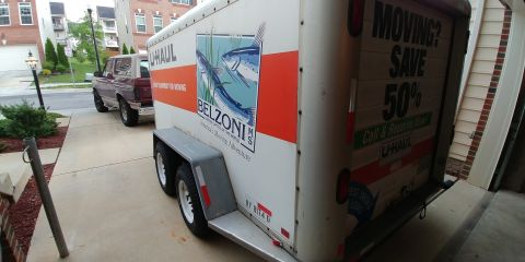 1996 Ford Bronco - A Ford Bronco is parked on a driveway next to a U-Haul moving trailer.