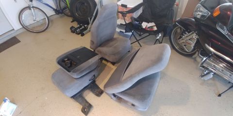 1996 Ford Bronco - Interior car seats and center console are disassembled and laid out on a garage floor.
