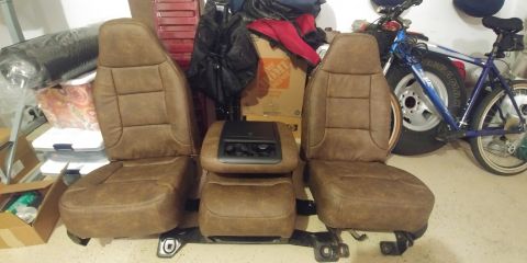 1996 Ford Bronco - Interior parts, likely from a truck or SUV, are laid out on the floor.