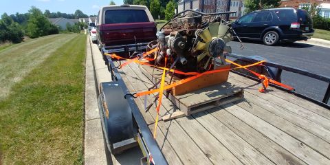1996 Ford Bronco - An engine is secured to a trailer, with a Ford Bronco and an SUV visible.