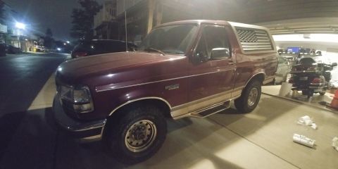1996 Ford Bronco - This Ford Bronco has a two-tone paint scheme and an American flag decal on the rear window.