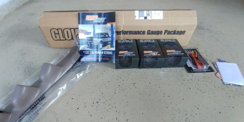 1996 Ford Bronco - Unboxed performance gauges and installation guide for a 7.3L Power Stroke engine are laid out on a concrete floor.