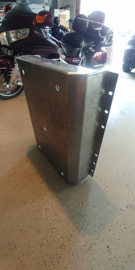 1996 Ford Bronco - A metal skid plate is shown in a garage with motorcycles visible in the background.