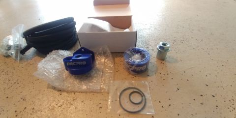1996 Ford Bronco - PACPRO oil filter relocation kit components laid out on a textured surface.