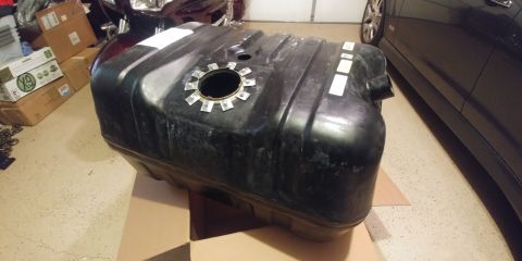 1996 Ford Bronco - Fuel tank shown in a garage setting with boxes and a car in the background.
