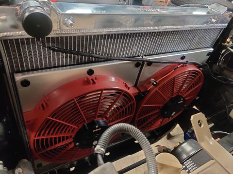 1996 Ford Bronco - Close-up view of dual red electric fans attached to an aluminum radiator, likely part of an engine bay upgrade.