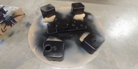 1996 Ford Bronco - Engine components freshly painted black and drying on a turntable, with overspray visible on the surface.