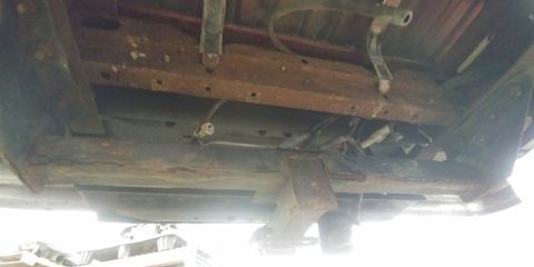 1996 Ford Bronco - The underside of a vehicle shows significant rust on the frame and suspension components, indicating potential structural issues.