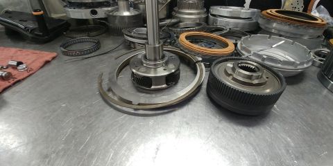1996 Ford Bronco - Various transmission parts are laid out on a workbench, suggesting a repair or rebuild process.